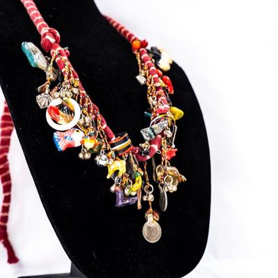 Sale Photo Thumbnail #452: This is a handcrafted charm neckace featuring a hand-dyed scarf base approximately 56 milagros and charchkas from around the world.
