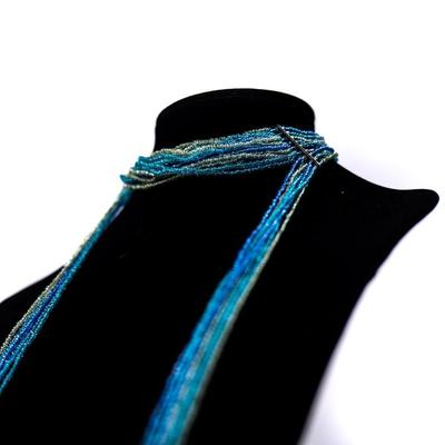 Sale Photo Thumbnail #458: This is a multistrand seed bead necklace in shades of blue, green, and white.