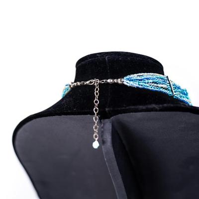 Sale Photo Thumbnail #459: This is a multistrand seed bead necklace in shades of blue, green, and white.