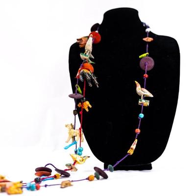 Sale Photo Thumbnail #469: This is a unique, handmade folk art necklace featuring carved and painted animals and disk beads. 1 animal has damage.