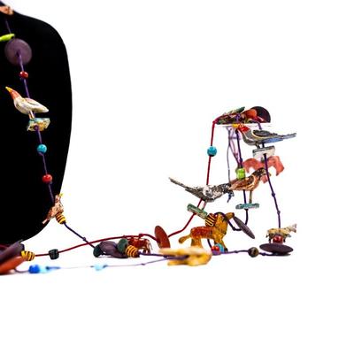 Sale Photo Thumbnail #467: This is a unique, handmade folk art necklace featuring carved and painted animals and disk beads. 1 animal has damage.