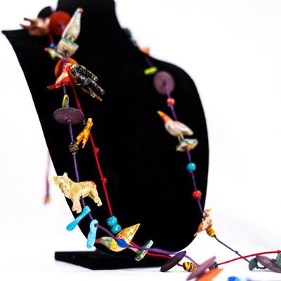 Sale Photo Thumbnail #466: This is a unique, handmade folk art necklace featuring carved and painted animals and disk beads. 1 animal has damage.
