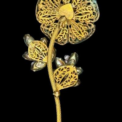 Sale Photo Thumbnail #186: This ornate costume piece was designed by Frank Hess, who also designed for Miriam Haskell. It has detailed filigree with hand blown colored glass beads and marquise cut jadeite. It was made in NYC. Measurement: 3.75”L. Pre-auction estimate: $100-$200. 