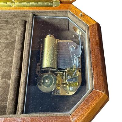 Sale Photo Thumbnail #199: Made by Reuge, in Italy. This piece has fine marquetry inlay in a floral motif, and an internal music box. Includes the original key. Measurement; 12”L x 6.5”W. Pre-auction estimate: $100-$150. [JP]