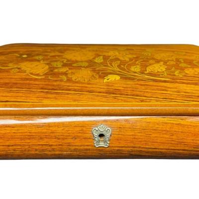 Sale Photo Thumbnail #197: Made by Reuge, in Italy. This piece has fine marquetry inlay in a floral motif, and an internal music box. Includes the original key. Measurement; 12”L x 6.5”W. Pre-auction estimate: $100-$150. [JP]