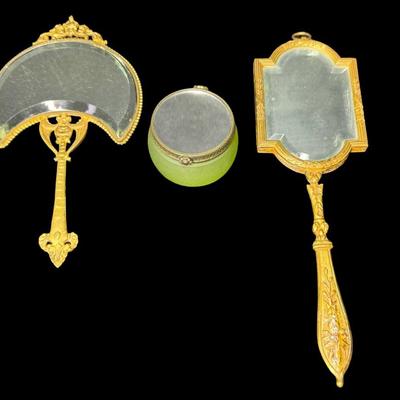 Sale Photo Thumbnail #231: Includes a porcelain Art Nouveau mirror, a brass portrait miniature mirror, and a French powder jar. Total of three pieces. There is age related wear, but all pieces are intact and unbroken. Measurement of longest: 8.75”L. Pre-auction estimate: $200-$30