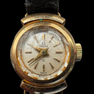 Sale Photo Thumbnail #313: This is stamped “18K” on the inside. The back is stamped “Solvil et Titus, Geneva, 5658.” The band is leather, and has age related wear. The overall weight is 8.65 grams. Not tested. [JP]