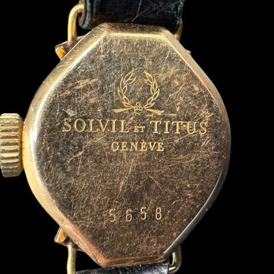 Sale Photo Thumbnail #314: This is stamped “18K” on the inside. The back is stamped “Solvil et Titus, Geneva, 5658.” The band is leather, and has age related wear. The overall weight is 8.65 grams. Not tested. [JP]