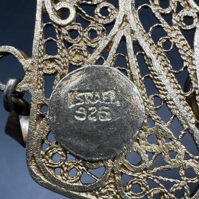 Sale Photo Thumbnail #336: [26.25g] This piece is marked “Israel, 925.” It features stunning filigree work, and has a green stone cabochon. There is a gold vermeil wash on this pendant. Measurement: 3.25”H x 2”W. [JP]