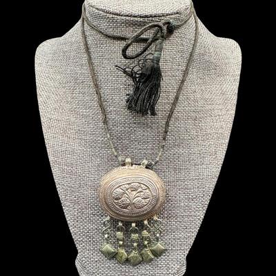 Sale Photo Thumbnail #349: [28.50g] This is believed to be a prayer box. It is on the original cord. There is age related wear. The weight is approximate, and does not include the cord. Measurement: 1.75”W x 3”H. Silver content confirmed using Niton XRF precious metals analyzer