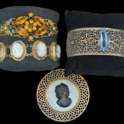 Sale Photo Thumbnail #358: Includes two bracelets with ornate filigree and semi-precious stones; a cameo pendant, and a carved nacre cameo bracelet. Total of four pieces. [JP]