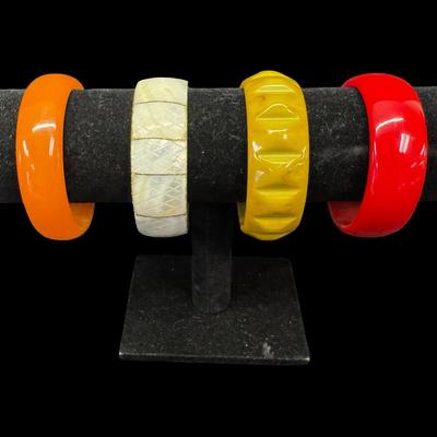 Sale Photo Thumbnail #368: Includes Bakelite, lucite, and mother of pearl bangle bracelets. Total of four pieces. These are most likely from the 1960s. Diameters range from 2.5” to 2.75”. [JP]