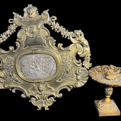 Sale Photo Thumbnail #410: Includes a dore’ tazza, and a brass European wall plaque with sterling silver insert. The wall plaque outside of the silver medallion in the center tests 70% silver, but has a brass appearance. Both pieces have age related wear. Measurement of largest: 
