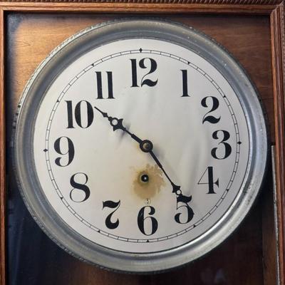Sale Photo Thumbnail #422: This antique regulator clock has solid oak construction. The integrity of the case and pendulum is solid. There is discoloration in the center of the porcelain face. Not tested. Measurement: 36”H x 18”W. Pre-auction estimate: $100-$150. [RS]
