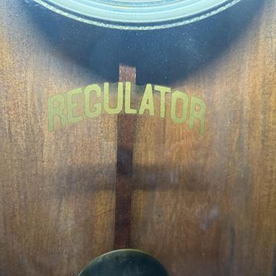 Sale Photo Thumbnail #421: This antique regulator clock has solid oak construction. The integrity of the case and pendulum is solid. There is discoloration in the center of the porcelain face. Not tested. Measurement: 36”H x 18”W. Pre-auction estimate: $100-$150. [RS]