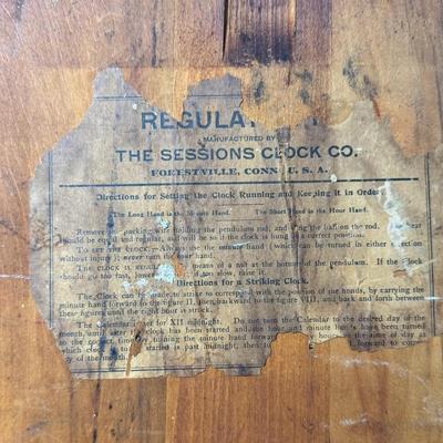 Sale Photo Thumbnail #419: This antique regulator clock has solid oak construction. The integrity of the case and pendulum is solid. There is discoloration in the center of the porcelain face. Not tested. Measurement: 36”H x 18”W. Pre-auction estimate: $100-$150. [RS]
