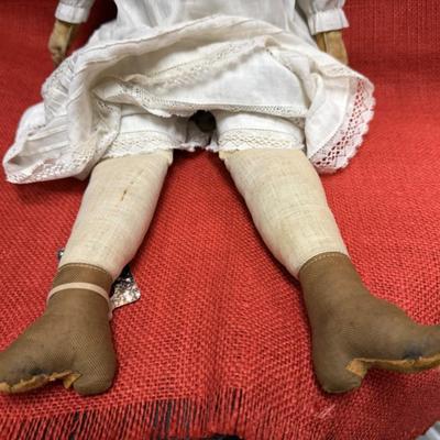 Sale Photo Thumbnail #30: This beauty has a cloth body , lace dress, leather hands, porcelain/China head and shoulders, blue eyes.
22 inches long.  Did she cross the prairie in a covered wagon?