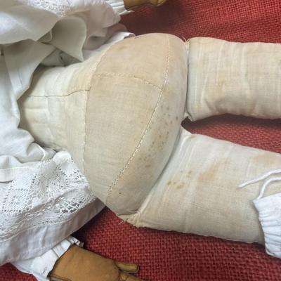 Sale Photo Thumbnail #29: This beauty has a cloth body , lace dress, leather hands, porcelain/China head and shoulders, blue eyes.
22 inches long.  Did she cross the prairie in a covered wagon?