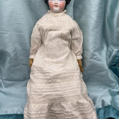Sale Photo Thumbnail #25: This beauty has a cloth body , lace dress, leather hands, porcelain/China head and shoulders, blue eyes.
22 inches long.  Did she cross the prairie in a covered wagon?