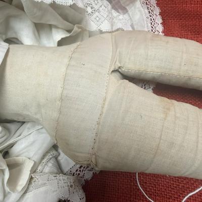 Sale Photo Thumbnail #28: This beauty has a cloth body , lace dress, leather hands, porcelain/China head and shoulders, blue eyes.
22 inches long.  Did she cross the prairie in a covered wagon?