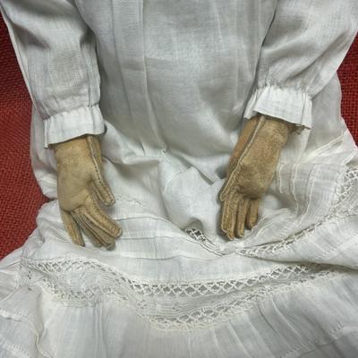 Sale Photo Thumbnail #27: This beauty has a cloth body , lace dress, leather hands, porcelain/China head and shoulders, blue eyes.
22 inches long.  Did she cross the prairie in a covered wagon?