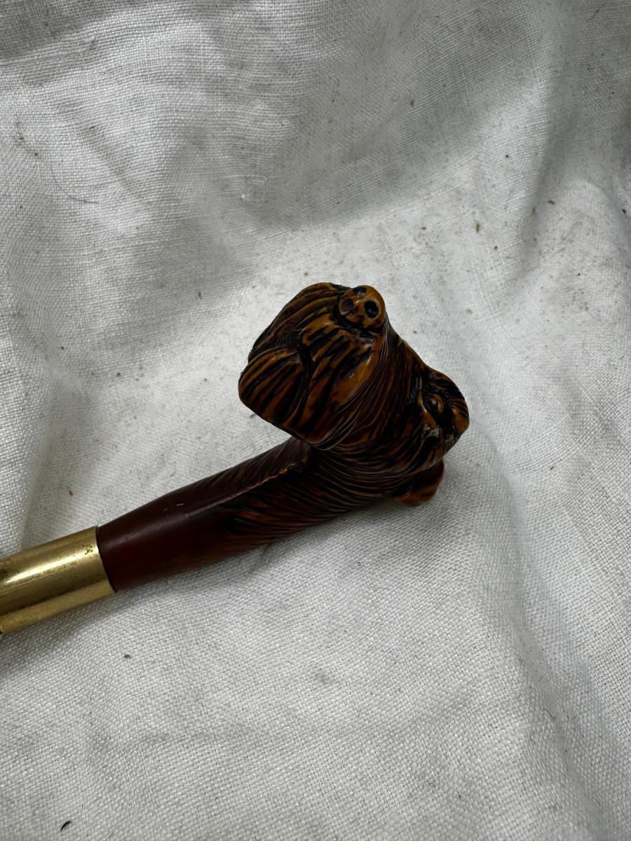 Sale Photo Thumbnail #552: Dog head (resin) with shell horn, marked with a drop of paint, Taiwan Brass Dog head stick breaks apart and top containes a corked glass vial , under that is a spring, and then the bottom third screws off too!
