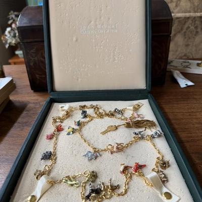 Sale Photo Thumbnail #100: This is a vintage Joan Rivers Noah's Ark charm necklace featuring numerous small, colorful,
enameled animal charms in the original leather gift box with a key.  The necklaces are known for their intricate charms and are designed so that sections can be re