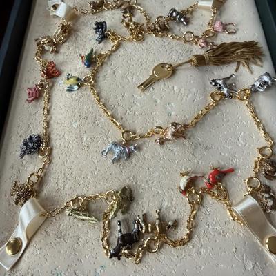 Sale Photo Thumbnail #101: This is a vintage Joan Rivers Noah's Ark charm necklace featuring numerous small, colorful,
enameled animal charms in the original leather gift box with a key.  The necklaces are known for their intricate charms and are designed so that sections can be re
