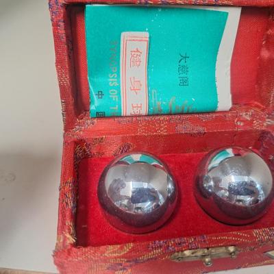 Chinese Baoding balls, also known as Chinese stress balls, meditation balls, or health balls, presented in a red silk box. 