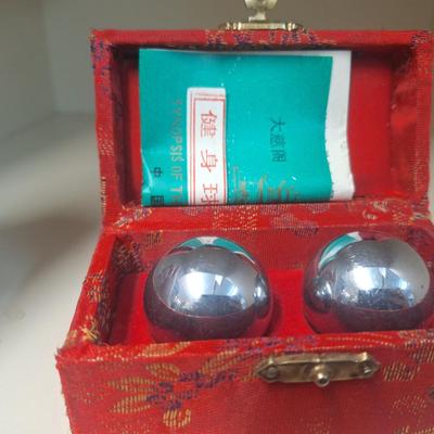 Chinese Baoding balls, also known as Chinese stress balls, meditation balls, or health balls, presented in a red silk box. 