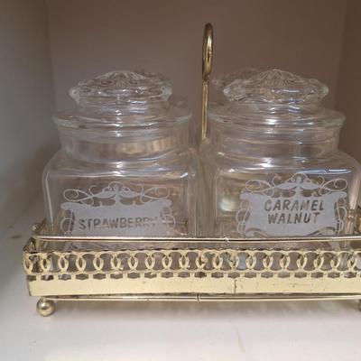 set of four glass apothecary jars in gold tone metal holder caddy, jars have etched design see all photos.