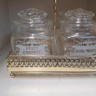 set of four glass apothecary jars in gold tone metal holder caddy, jars have etched design see all photos.