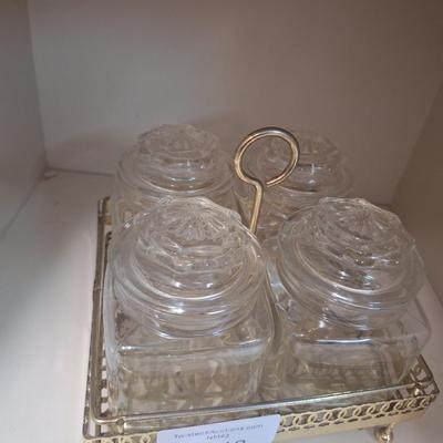 set of four glass apothecary jars in gold tone metal holder caddy, jars have etched design see all photos.