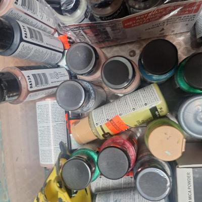 container of various craft paints and supplies. Container has lid but lid doesn't fasten down.