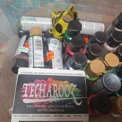 container of various craft paints and supplies. Container has lid but lid doesn't fasten down.