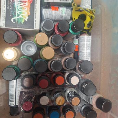 container of various craft paints and supplies. Container has lid but lid doesn't fasten down.