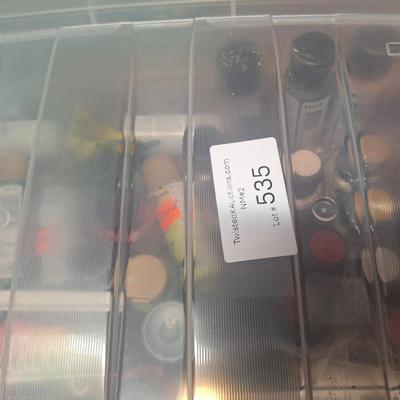 container of various craft paints and supplies. Container has lid but lid doesn't fasten down.