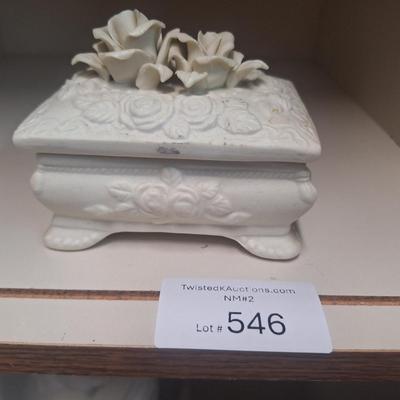 vintage ceramic or porcelain footed trinket box featuring an embossed rose design and three-dimensional roses on the lid. 