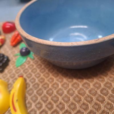 collection of vintage fruit and vegetable-themed refrigerator magnets and a pottery bowl to keep them in.