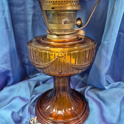 Sale Photo Thumbnail #156: 19.5 inches tall
Mottled amber glass ruffled/scalloped at the top.
Amber glass base with swag decoration
Aladdin burner assembly 
very good condition