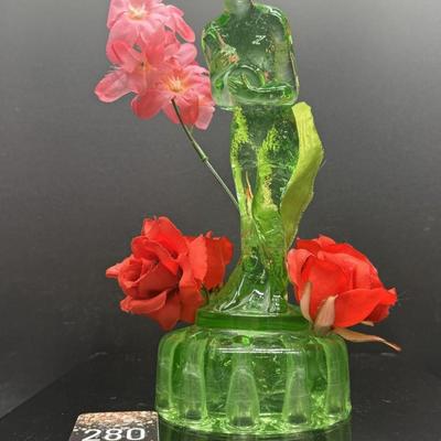Sale Photo Thumbnail #169: Bashful Charlotte, uranium glass  made by Cambridge Glass Co, 1930s
Has 10 holes for flowers ,depicts nude figure holding a flask
9 inches tall
Very good condition