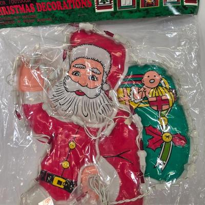 LOT 92: Two Lighted Santa Claus Christmas Window Decor, Two Miniature Noel Candle Trains, and Jolly St Nick Collection Two Jovial Holiday...