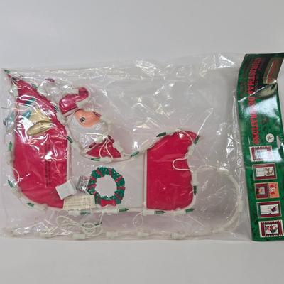 LOT 92: Two Lighted Santa Claus Christmas Window Decor, Two Miniature Noel Candle Trains, and Jolly St Nick Collection Two Jovial Holiday...