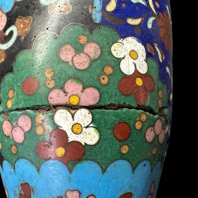 Sale Photo Thumbnail #534: Polychrome design of flowers and butterflies on a midnight blue background. This piece has one crack in the enamel (pictured). Measurement: 6”H x 3.25”W. [BK]