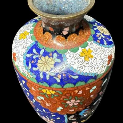 Sale Photo Thumbnail #532: Polychrome design of flowers and butterflies on a midnight blue background. This piece has one crack in the enamel (pictured). Measurement: 6”H x 3.25”W. [BK]