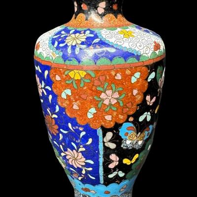 Sale Photo Thumbnail #531: Polychrome design of flowers and butterflies on a midnight blue background. This piece has one crack in the enamel (pictured). Measurement: 6”H x 3.25”W. [BK]