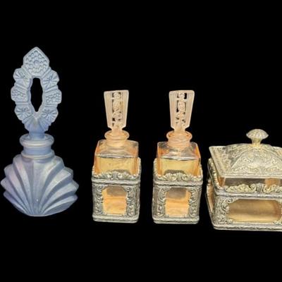 Sale Photo Thumbnail #563: Includes three perfumes, a silver tone trinket box with pink glass insert, and an enamelware Toleware metal trinket box. There is age related wear and minimal paint loss to the Toleware piece. The two pink perfume bottles have damaged stoppers. [BK]