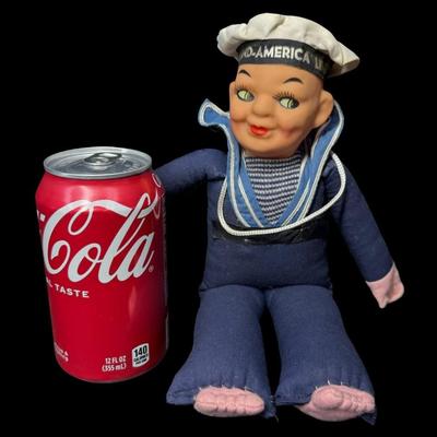 Sale Photo Thumbnail #582: This has a cloth body with a composite head. It is possibly made by Norah Wellings. It was a souvenir or memento of a cruise. There is some age related wear. Measurement: 10”H. [BK]