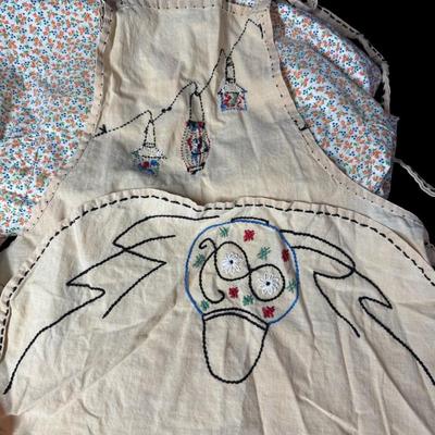 Sale Photo Thumbnail #629: Includes a silk Daytona Beach apron, a floral seed apron, and more. Total of four pieces. There is age related wear, including some stains. [BK]