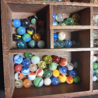SECTIONED WOODEN BOX WITH A VARIETY OF MARBLES